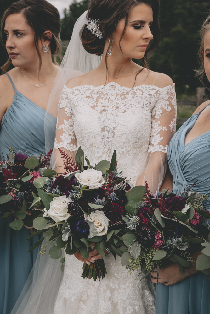 Wisconsin Dells Summer wedding with deep burgundy flowers and dusty blue bridesmaid dresses at Glacier Canyon by Sara Anne Johnson. Sara Johnson Photography