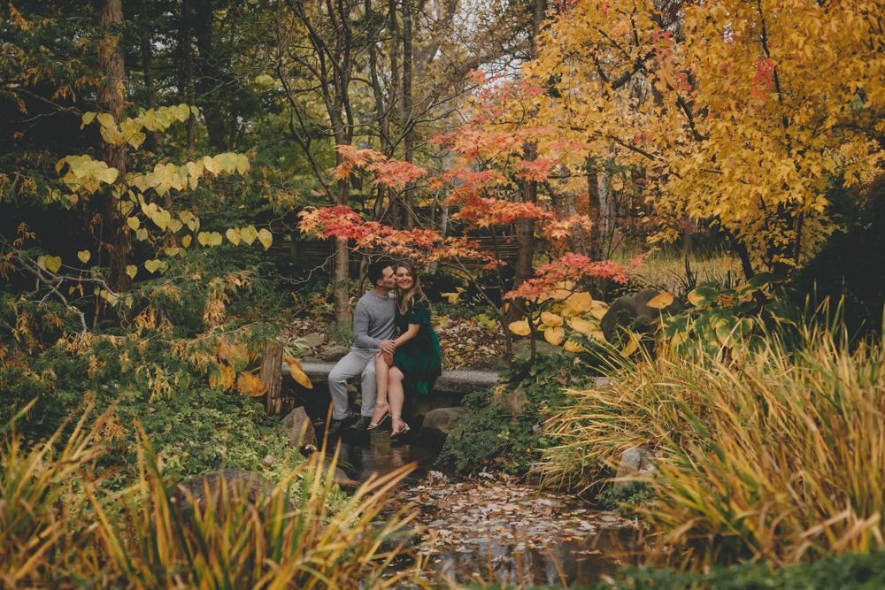 Fall, sunset engagement session with emerald green velvet dress and blue sapphire engagement ring at Anderson Japanese Gardens in Rockford, IL by Sara Anne Johnson - Photographer